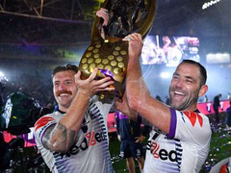 Cameron Munster e Cameron Smith soslèvan lo trofèu de campion NRL