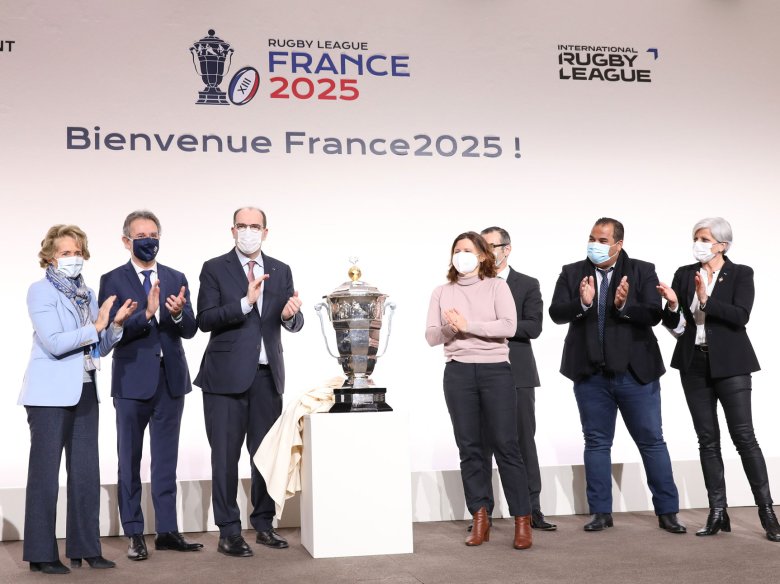 L’anóncia de la tenguda de las Copas del Mond de XIII (òmes, femnas, joves e cadieral) en 2025 en França (París, dimars 11 de genièr). De part e d’autre de la Copa: lo primièr ministre Joan Castèths e la ministra dels espòrts Roxana Marcineanu